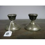 A Pair of hallmarked Silver Dwarf Candlesticks, each with reeded decoration, (bases weighted). (2)