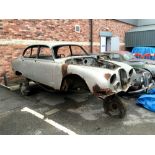 1967 Jaguar S-Type Bodyshell in Silver, sat on a mobile dolly frame for transportation.