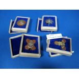 Four XX Century Japanese Military Bronze Badges, all naval related, in wooden presentation cases.