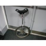 A Unicycle, with dished seat, chrome frame.