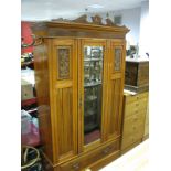 An Edwardian Walnut Wardrobe, carved cresting plain frieze over central mirrored door and lower