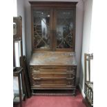 A 1920's Oak Bureau Bookcase, having stepped pediment and astragal doors over fall front, three