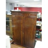 A XIX Century Mahogany Wardrobe, with stepped cornice and twin panelled doors, on a plinth base,