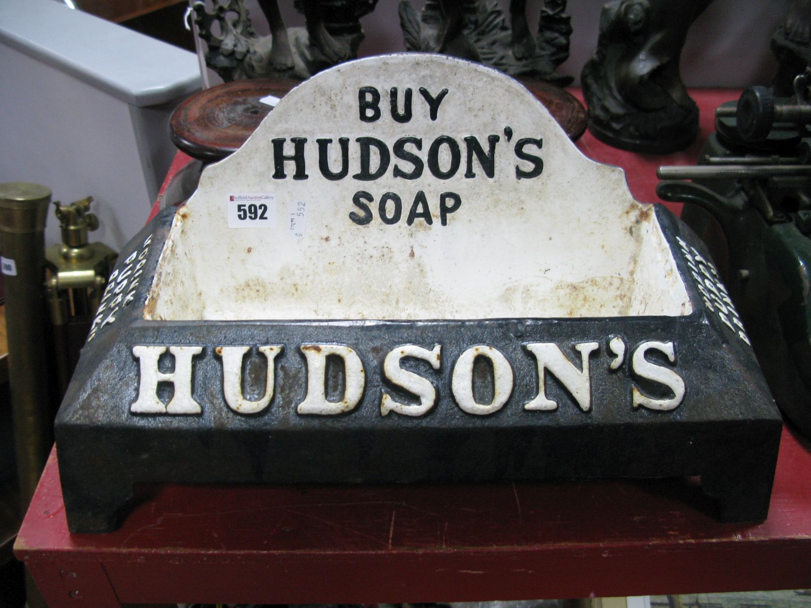 A Hudson's Soap Advertising Cast Iron Dogs Water Bowl, painted in monochrome stating "Buy Hudson's