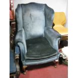 A Late XIX Century Wingback Armchair, upholstered in blue velvet over cabriole legs on pad feet.