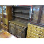 Oak Dresser, with planked rack, symmetrical twin drawers over door having reeded side.