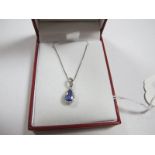 A Modern Tanzanite and Diamond Pear Shape Pendant, three claw set to the centre, within border of