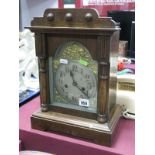 Early XX Century Oak Cased Metal Clock, with a shaped pediment, arch, silvered dial, on a plinth