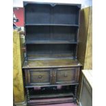 A 1920's Oak Dresser, the rack with two shelves, panelled back base, having two cupboard doors on