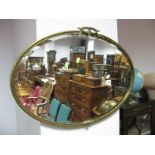 An Early XX Century Oval Bevelled Wall Mirror, in brass frame having applied cresting.