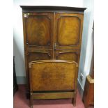 A XX Century Mahogany Serpentine Shaped Wardrobe, with a dentil cornice, panelled doors on bracket