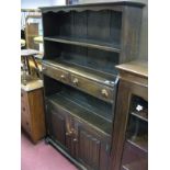 A XX Century Oak Dresser, with a shaped freeze, open shelf over two small central drawers above an