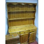 A Modern Pine Dresser, wavy apron piece over three plate racks, the base with three frieze drawers