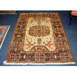 A Persian style rug, the foliate motif on cream ground with multi coloured foliate border,