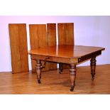 A late 19th/early 20th century oak extending dining table,