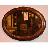 A mahogany veneered shaped wall mirror,