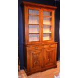 A late Victorian oak bookcase on cupboard base,