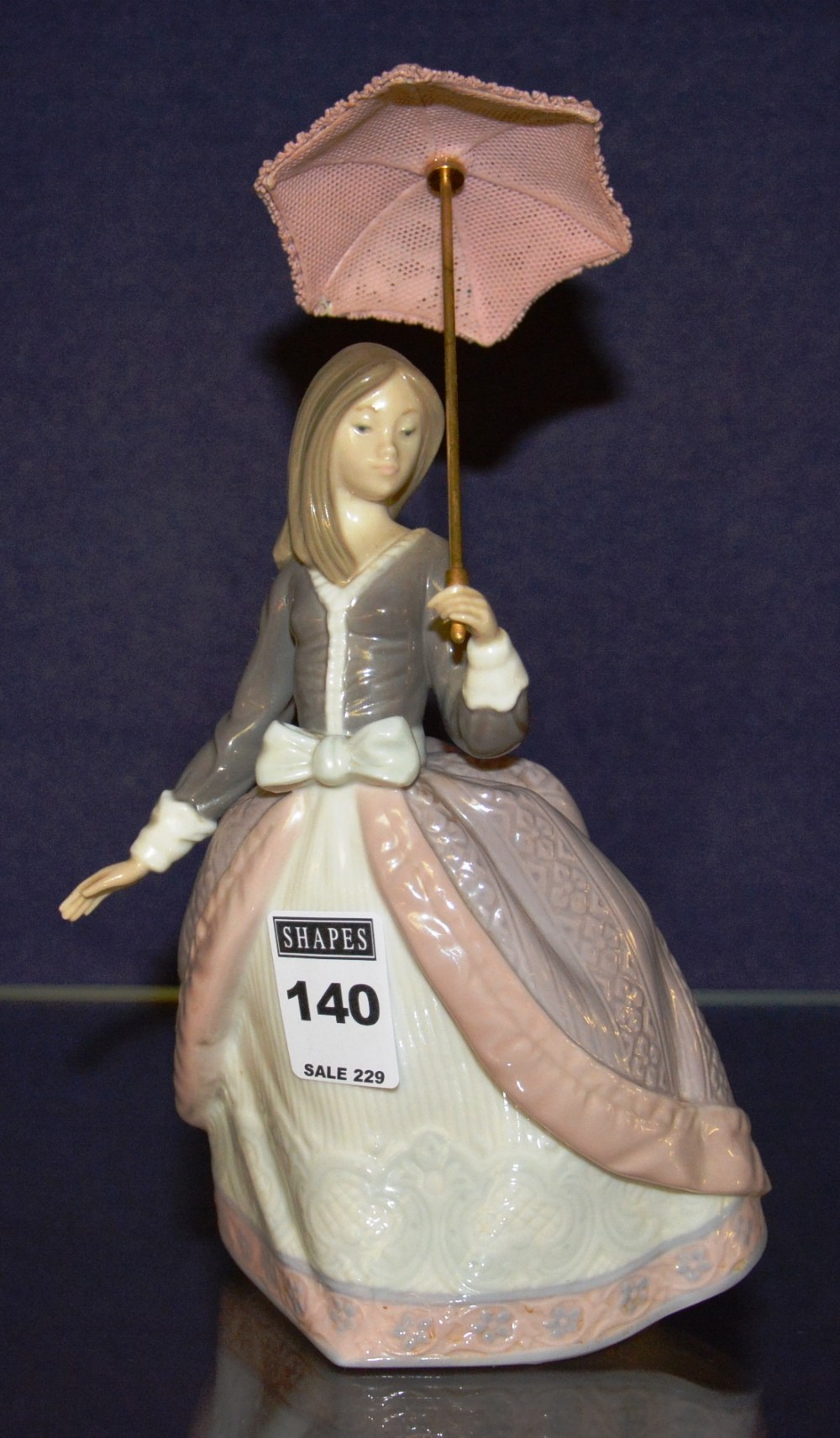 A Lladro figure of a girl holding parasol,