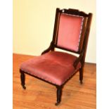 A late Victorian mahogany framed parlour armchair, upholstered in pink velour,