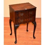 A reproduction mahogany bedside cabinet, with two drawers, raised on cabriole supports,