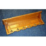 A French style oak wall mounting hat and coat rack, decorated with six metal mask hooks,