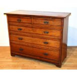 An Edwardian oak chest of drawers, with two short drawers above three graduated drawers,