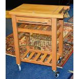 A contemporary butchers block tea table with drawer, under rack and undertier raised on castors,