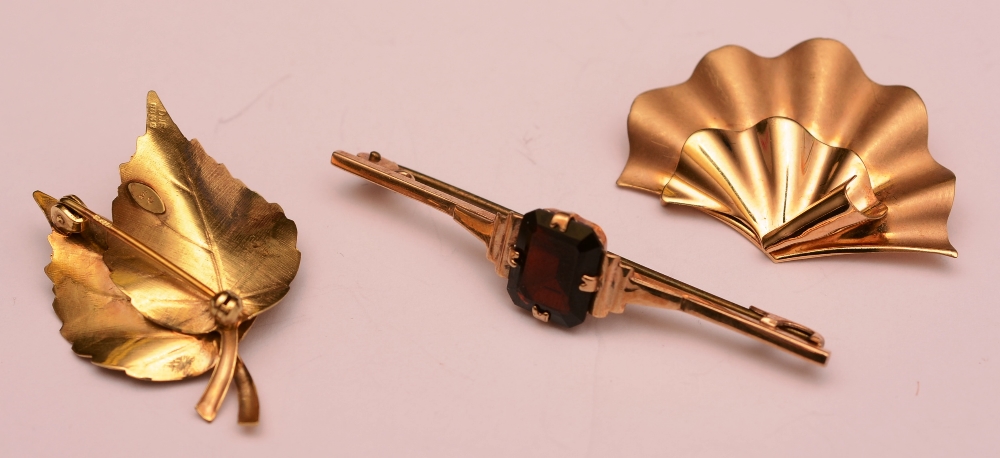 A 9ct gold and garnet bar brooch, 5cm long, 3g, together with a 9ct gold leaf brooch, 3g,