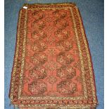 A small Persian floor rug, decorated with seven rows of two geometric medallions, on rust ground,