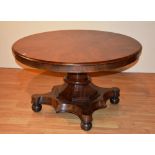 An early 19th century Regency mahogany breakfast table, the circular top raised on cylinder column,