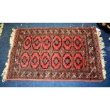 A Persian prayer mat, decorated with six rows of two geometric medallions, on red and blue ground,