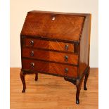 A walnut writing bureau, raised on cabriole supports,