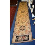 A machine woven floor runner, decorated with five floral panels on cream and black ground,