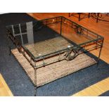 A wrought iron and wicker work coffee table, with glass top,