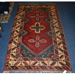 A Persian rug, decorated with three cross motifs to the centre, floral and geometric border,