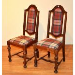 A pair of early 20th century 17th century style oak hall chairs, upholstered in later tartan fabric,