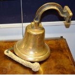 A brass ships bell, with bracket attachment and rope,