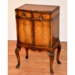 A Queen Anne style walnut bedside cabinet, raised on cabriole supports with pad feet,