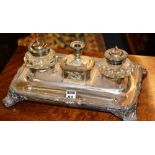 A plated deskstand, early 20th century, with integral glass inkwells, raised on scroll feet,