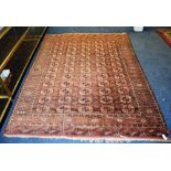 A Persian rug, decorated with five rows of 12 geometric motifs with dog tooth border,