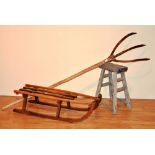 A vintage wooden sleigh, 24cm high x 99cm long, together with a rustic wood stool, 54cm high,