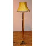 A brass Corinthian style floor lamp with shade, converted to electricity,