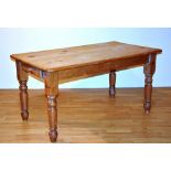 A pine rectangular kitchen table, with drawer to one side, raised on turned supports,