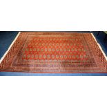 A Persian Bokhara rug, decorated with 16 rows of four medallions,