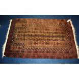 A small Persian rug, with geometric decoration on brown ground,