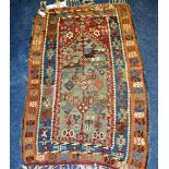 A small Persian floor rug, with geometric decoration on multi-coloured ground, tassels to each end,