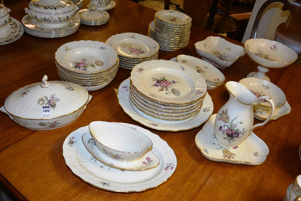 A Royal Copenhagen dinner set, decorated with colourful floral panels, on ivory coloured grounds,