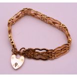 A 9ct gold padlock bracelet, with brick and cross link decoration, stamped 9ct to padlock,