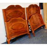 A pair of Queen Anne style walnut single beds, with later bases, mattresses and irons,
