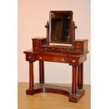 A Victorian mahogany breakfront dressing table, raised on cylinder columns and platform base,